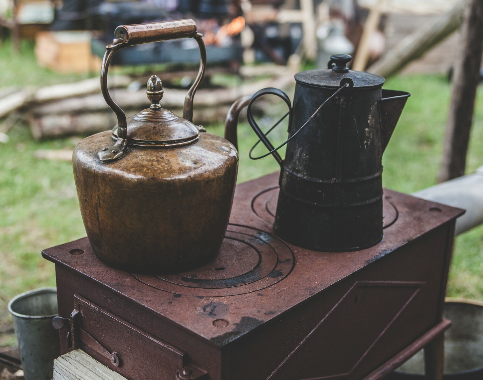 Two old brass tea pots on a stove